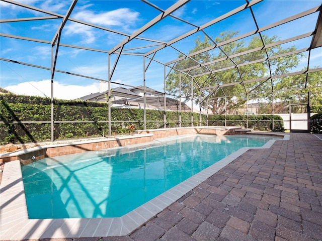 view of pool with glass enclosure, a patio area, and a fenced in pool