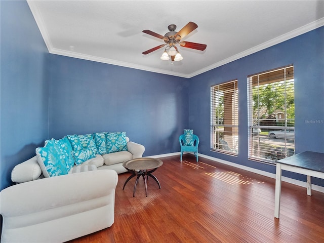 living area with ceiling fan, baseboards, wood finished floors, and crown molding