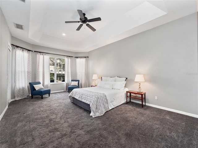 bedroom with visible vents, baseboards, carpet flooring, a raised ceiling, and ceiling fan