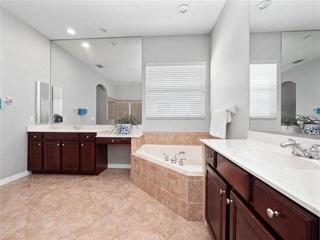 bathroom featuring visible vents, two vanities, a sink, tile patterned flooring, and a bath