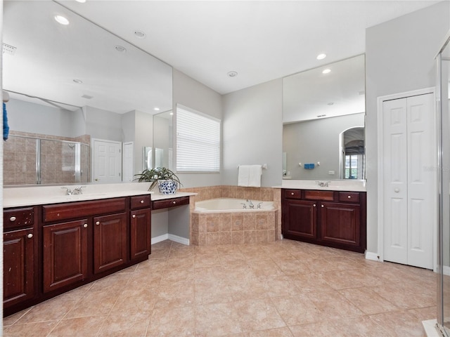 full bath featuring a bath, a stall shower, a closet, and a sink