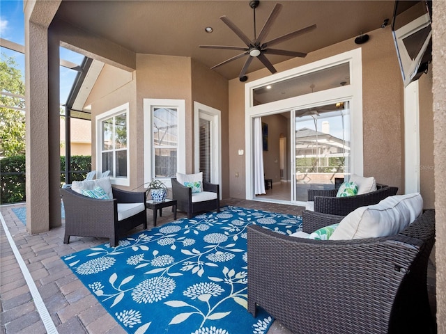 view of patio featuring a lanai, outdoor lounge area, and a ceiling fan