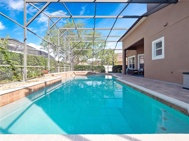 pool with glass enclosure and a patio