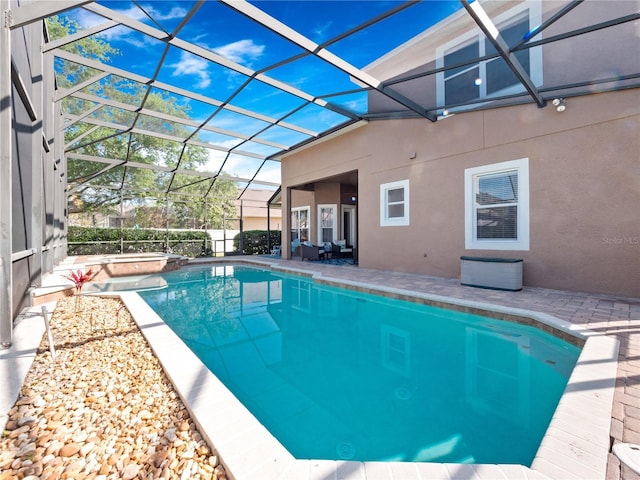 view of swimming pool with a patio area, a pool with connected hot tub, and a lanai