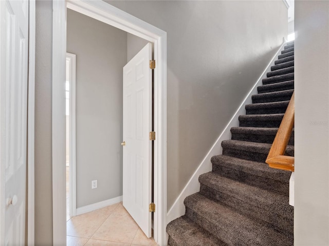 stairway featuring tile patterned flooring and baseboards