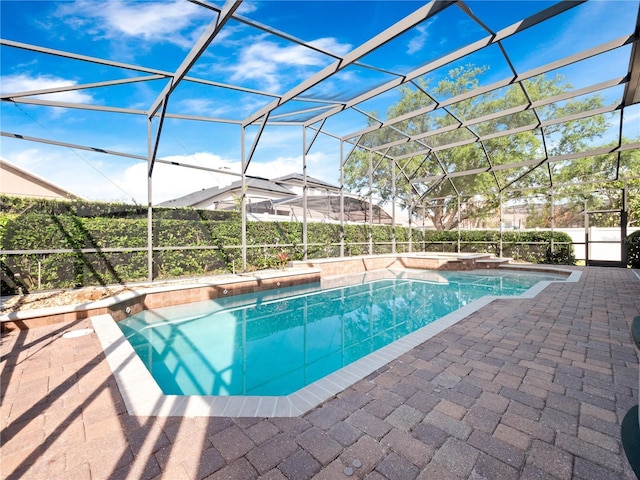 view of pool with a patio area, glass enclosure, and a fenced in pool