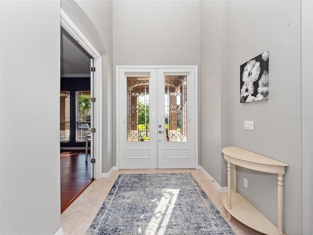 tiled foyer entrance with french doors and baseboards