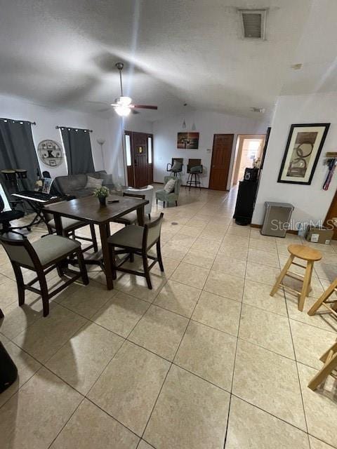 dining area with lofted ceiling, light tile patterned floors, ceiling fan, and visible vents