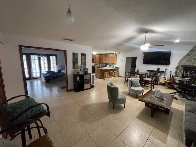 living room with light tile patterned floors, visible vents, and a ceiling fan