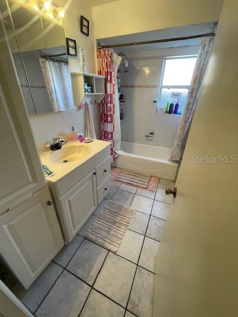 bathroom featuring tasteful backsplash, shower / bath combination with curtain, vanity, and tile patterned floors