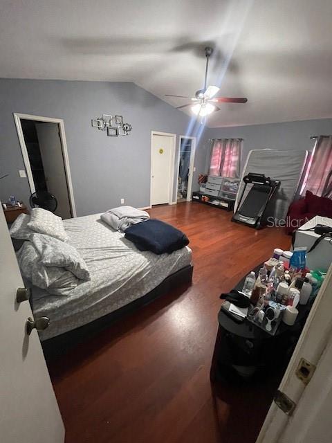 bedroom featuring lofted ceiling, wood finished floors, and a ceiling fan