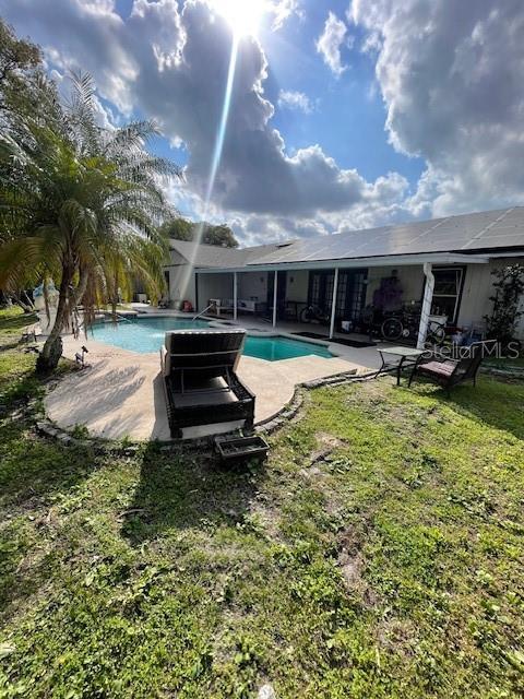 outdoor pool featuring a patio area and a yard