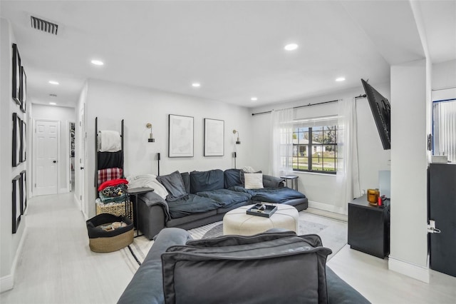 living room featuring baseboards, visible vents, and recessed lighting