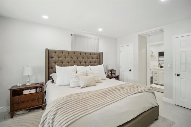 bedroom with ensuite bath, baseboards, attic access, and recessed lighting