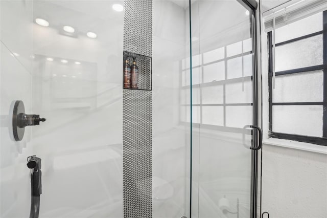 bathroom featuring a healthy amount of sunlight and a shower stall