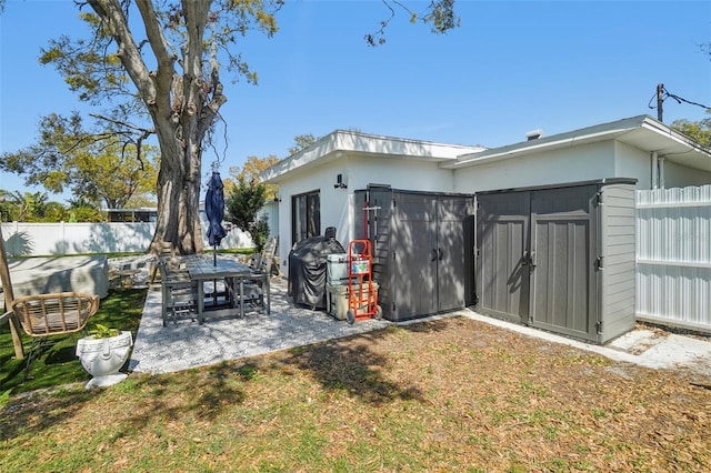 rear view of property featuring a lawn, a patio area, and a fenced backyard