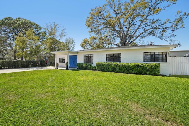 view of front of home featuring brick siding, fence, and a front yard