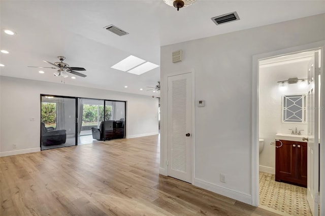 2502 SW 23rd Cranbrook Dr, Boynton Beach, FL 33436 - unfurnished living room featuring a skylight, a ceiling fan, visible vents, and light wood-style floors