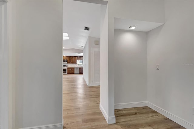 2502 SW 23rd Cranbrook Dr, Boynton Beach, FL 33436 - corridor featuring visible vents, baseboards, light wood-type flooring, and lofted ceiling