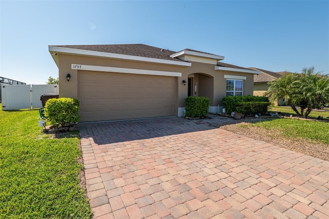 view of front of home with a gate, decorative driveway, an attached garage, and stucco siding