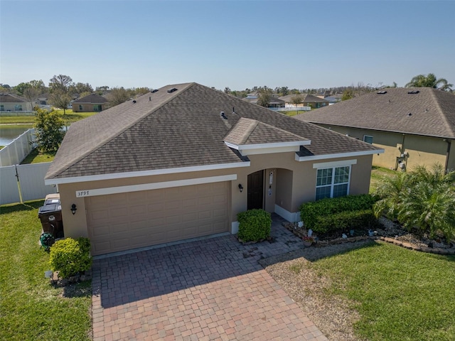 ranch-style home featuring a garage, a shingled roof, fence, decorative driveway, and stucco siding