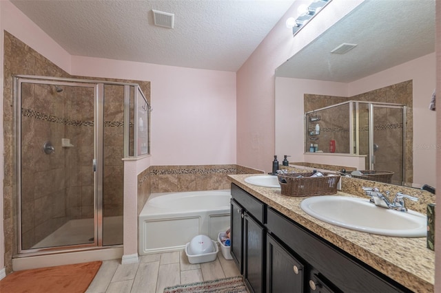 bathroom featuring a bath, a stall shower, visible vents, and a sink