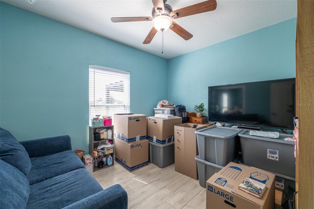 living room with ceiling fan and wood finished floors