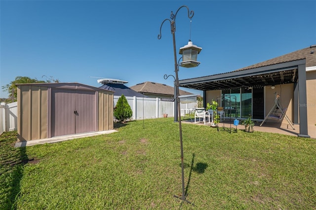 view of yard featuring a patio, a storage unit, an outdoor structure, and a fenced backyard