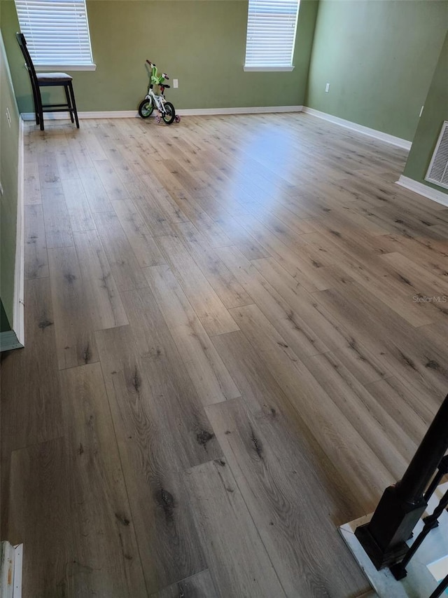 interior space featuring visible vents, wood finished floors, and baseboards