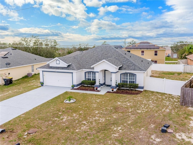 view of front of house featuring a front yard, concrete driveway, roof with shingles, and fence