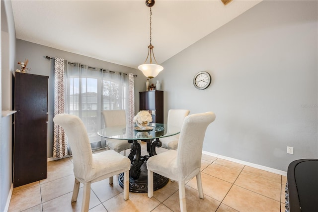 dining room with lofted ceiling, light tile patterned flooring, and baseboards