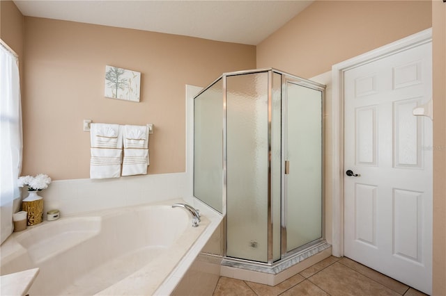 bathroom featuring a stall shower, a garden tub, and tile patterned floors