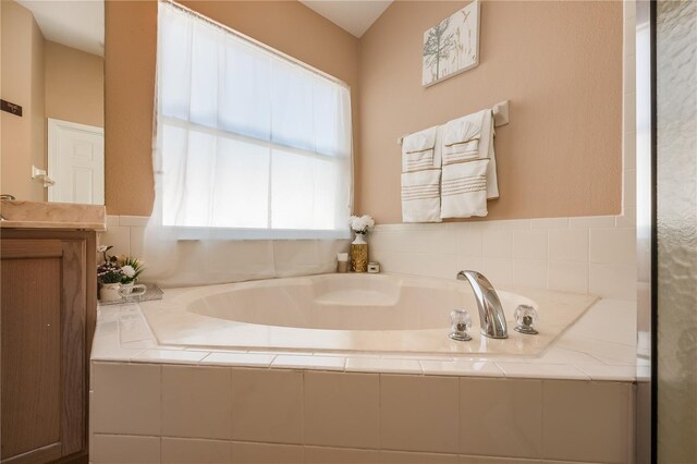 full bath with vanity and a bath