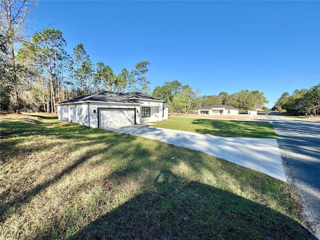 view of yard featuring driveway and a garage