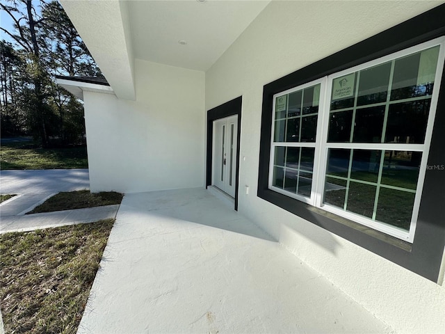 doorway to property featuring stucco siding