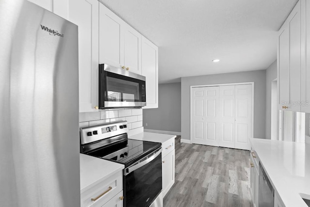 kitchen featuring white cabinets, stainless steel appliances, and light countertops