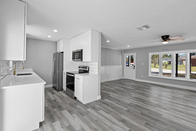 kitchen with tasteful backsplash, light countertops, visible vents, appliances with stainless steel finishes, and a sink