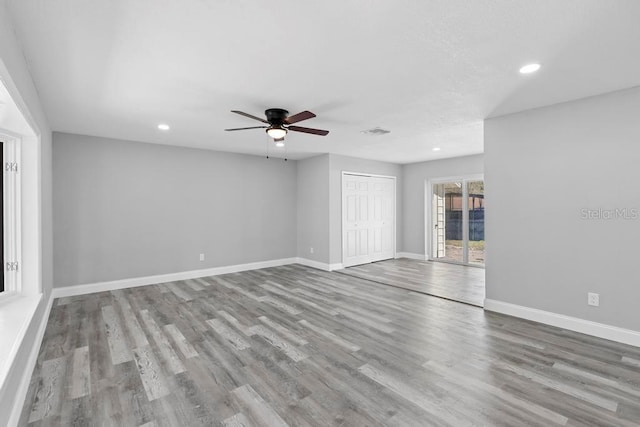 spare room with baseboards, visible vents, wood finished floors, and recessed lighting