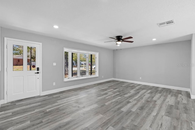 unfurnished living room with baseboards, visible vents, wood finished floors, and recessed lighting