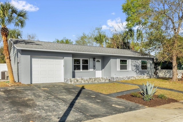 ranch-style house with stucco siding, an attached garage, central AC unit, and driveway