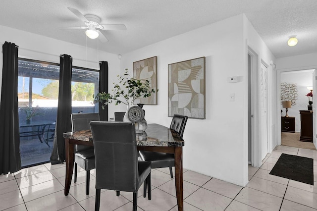 dining area featuring ceiling fan, light tile patterned floors, and a textured ceiling