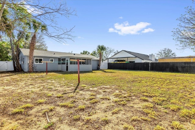 view of yard featuring a fenced backyard and a sunroom