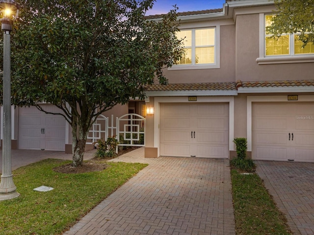 view of property featuring decorative driveway and stucco siding