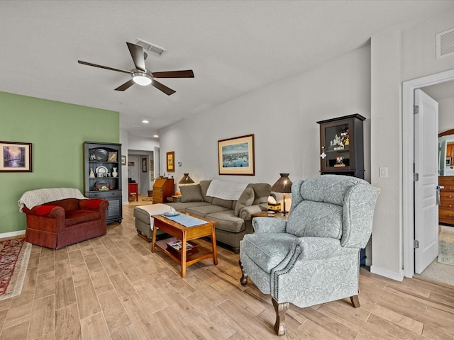 living room featuring light wood-type flooring, visible vents, ceiling fan, and baseboards