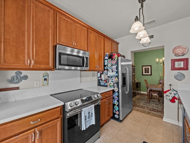 kitchen featuring visible vents, brown cabinets, stainless steel appliances, light countertops, and light tile patterned flooring