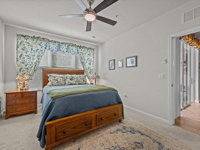 bedroom featuring visible vents, a ceiling fan, carpet flooring, a textured ceiling, and baseboards