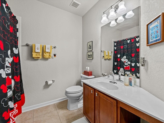 bathroom with toilet, vanity, baseboards, visible vents, and tile patterned floors