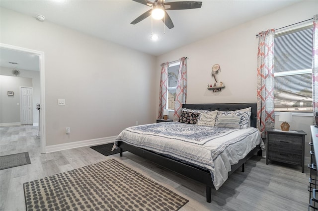 bedroom featuring baseboards, ceiling fan, and light wood-style floors