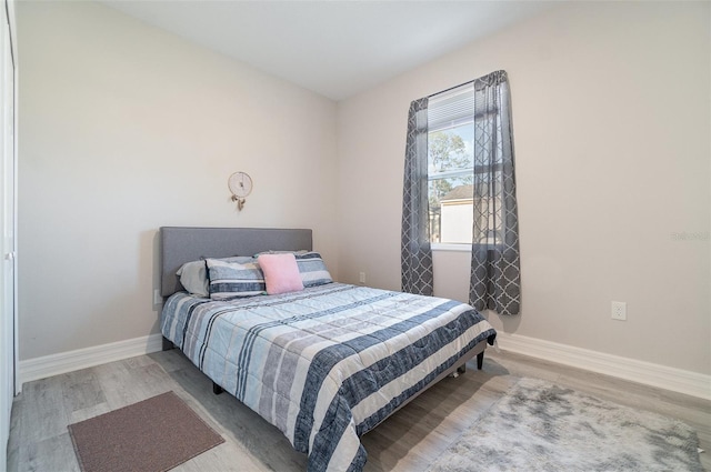 bedroom with baseboards and wood finished floors