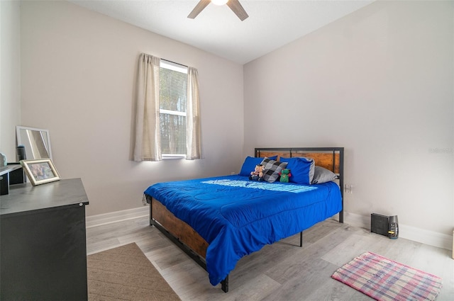 bedroom with wood finished floors, a ceiling fan, and baseboards